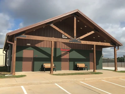 Building exterior with park benches and a restroom sign